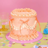 Vintage Cake - Tonal Colour with pastel pink Swiss Meringue icing, ribbons, and six-layer sponge by Crumbs & Doilies.